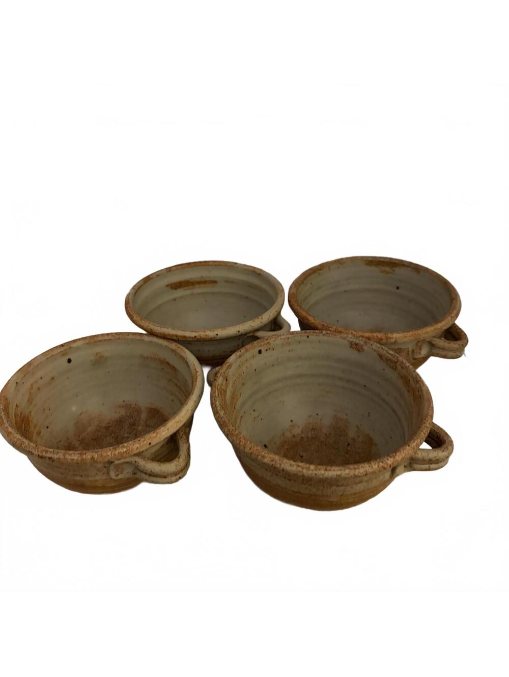 A set of four handmade speckled stoneware soup bowls with loop handles.